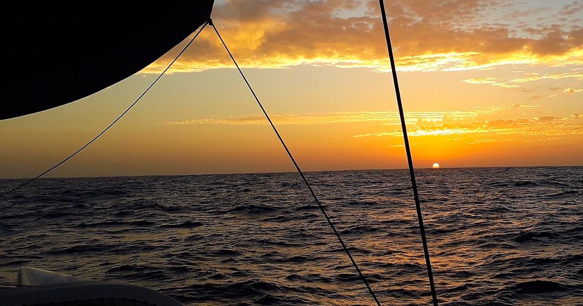 Golden sunset over the Atlantic Ocean framed by rigging on the Rapido 60 trimaran Ineffable.